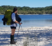 Load image into Gallery viewer, Female hiker wearing Aarn Hiking Pack with front pockets at the edge of a lake