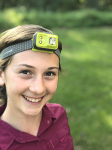 Young female, smiling, wearing a head torch