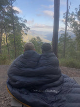 Load image into Gallery viewer, Two children wrapped in Sea to Summit quilt looking out over a valley