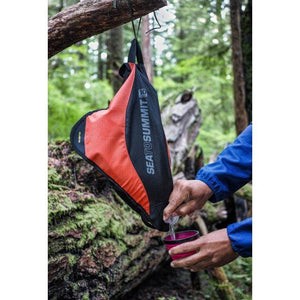 Sea To Summit Pack Tap 10L hanging from tree and being used to fill a mug