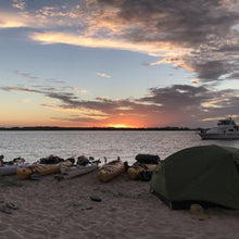 Load image into Gallery viewer, Luxe Habitat NX3 2-person hiking tent pitched on the beach next to a row of kayaks