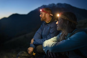 Two campers wearing Biolite head torches at night with the torch illuminated