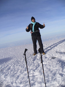 Male standing in snow smiling with Pacer poles in foreground