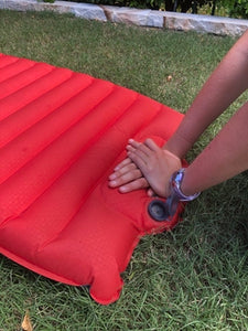 Hands on the integrated foot/hand pump of the NEMO Cosmo Insulated Sleeping Mat