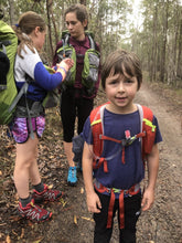 Load image into Gallery viewer, Child wearing Osprey Jet 18 pack front view with fellow hikers in background