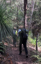 Load image into Gallery viewer, Male wearing Osprey Kestrel 58 Pack on hiking trail surrounded by trees