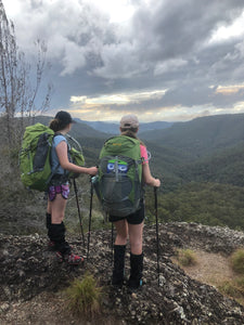 Two females using Pacer Poles at the top of a ridge overlooking a valley