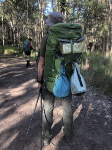 Hiker with Sea to Summit trash sack attached to the outside of his back pack